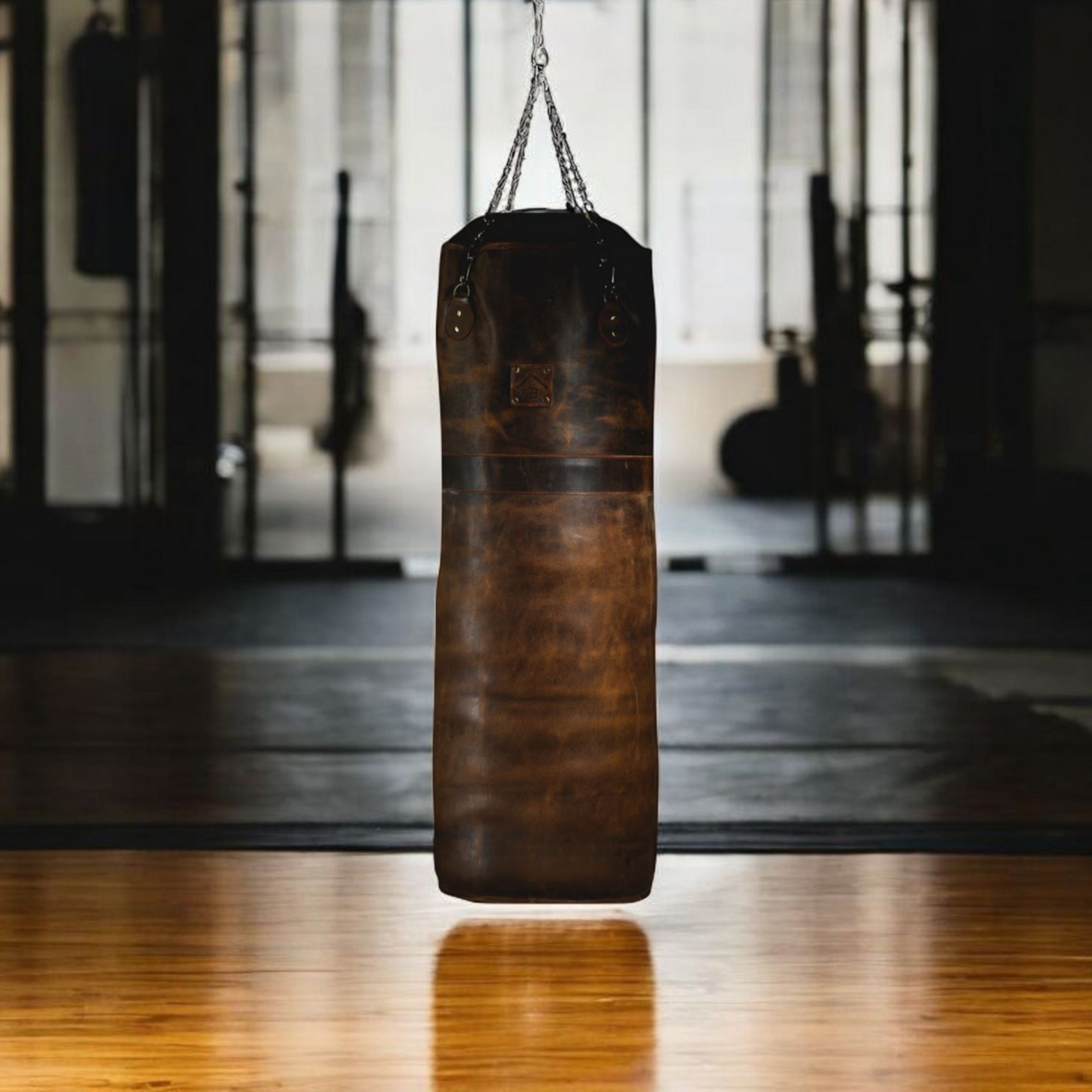 beautiful leather punching bag hanging in the gym with wooden floor.leather punching bag, heavy bag, boxing bag, kickboxing bag, Muay Thai heavy bag, free standing punching bag, hanging punching bag, speed bag, double end bag, aqua training bag, water heavy bag, uppercut bag, maize bag, wrecking ball bag, reflex bag, cobra bag, training dummy, professional heavy bag, gym punching bag, home gym heavy bag, filled punching bag, unfilled heavy bag, synthetic leather punching bag, durable heavy bag, 100lb punchi