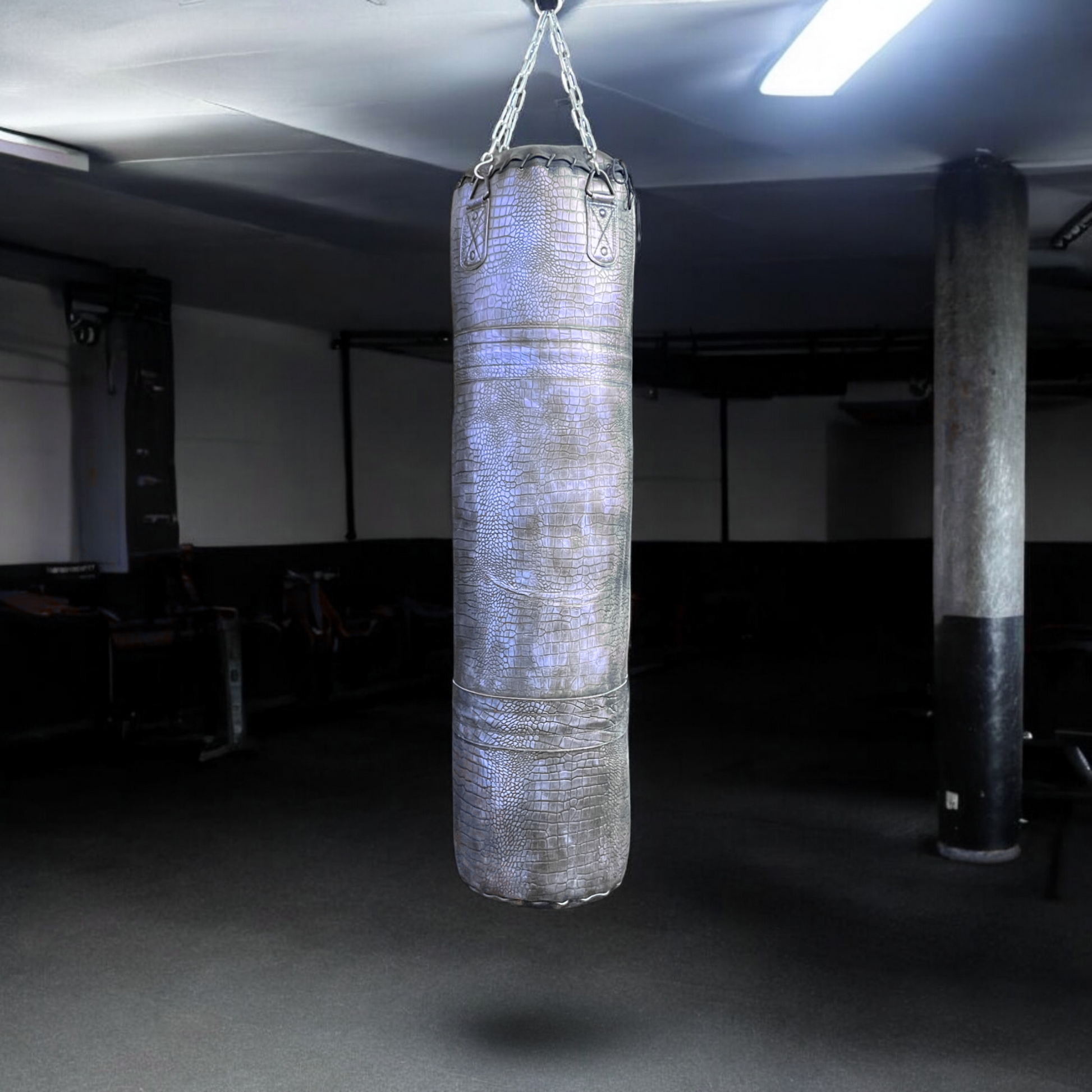 purple leather punching bag hanging from the ceiling in the dark background
