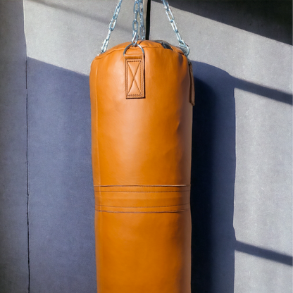 orange punching bag against the aesthetic background hanging with stainless steel chains
