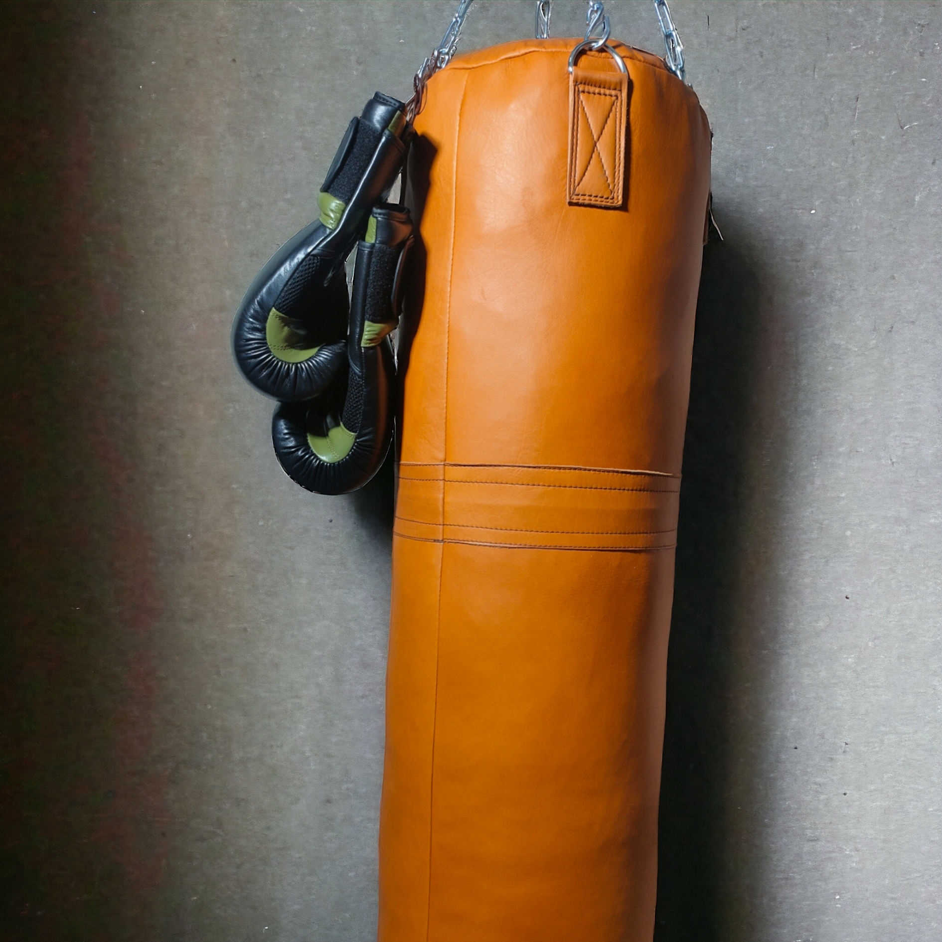 orange punching bag hanging with boxing gloves with aesthetic looks