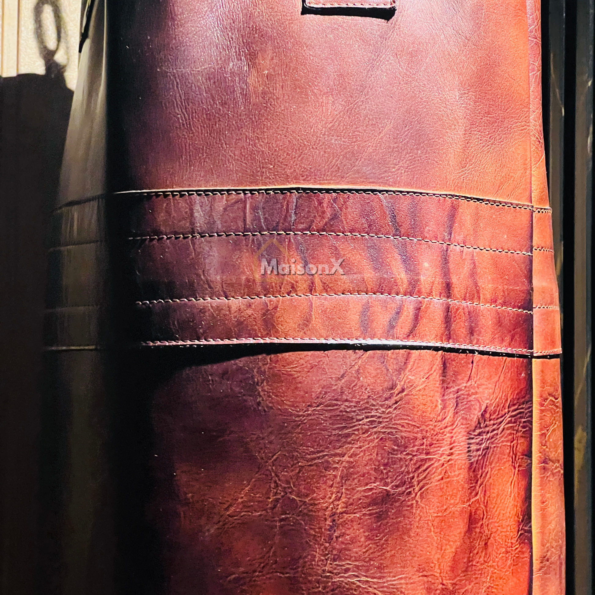 close up image of leather punching bag made up of cowhide showing leather strip connecting two panels of punching bag. giving extra strength to punching bag. boxing training equipment, mma training equipment, high quality finish, stitching, luxury product
