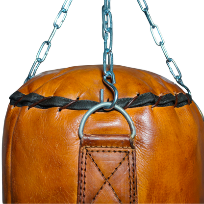Close-up photo showing the premium heavy-duty cowhide of the Unique PX200 Punching Bag, emphasizing the reinforced stitching and authentic vegetable tan finish. This durable handmade leather bag is a genuine leather heavy bag designed as professional gym gear for intensive Kickboxing Training and Boxing Bag for MMA. It ships as an unfilled punching bag